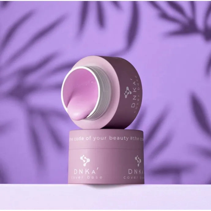 Pink DNKA cover base nail gel jar on purple background with palm shadows, professional manicure product