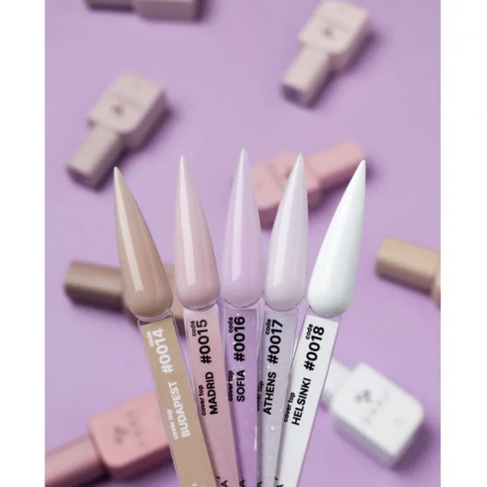 Assorted nude and pastel UV gel nail polish swatches on labeled testers against a purple background
