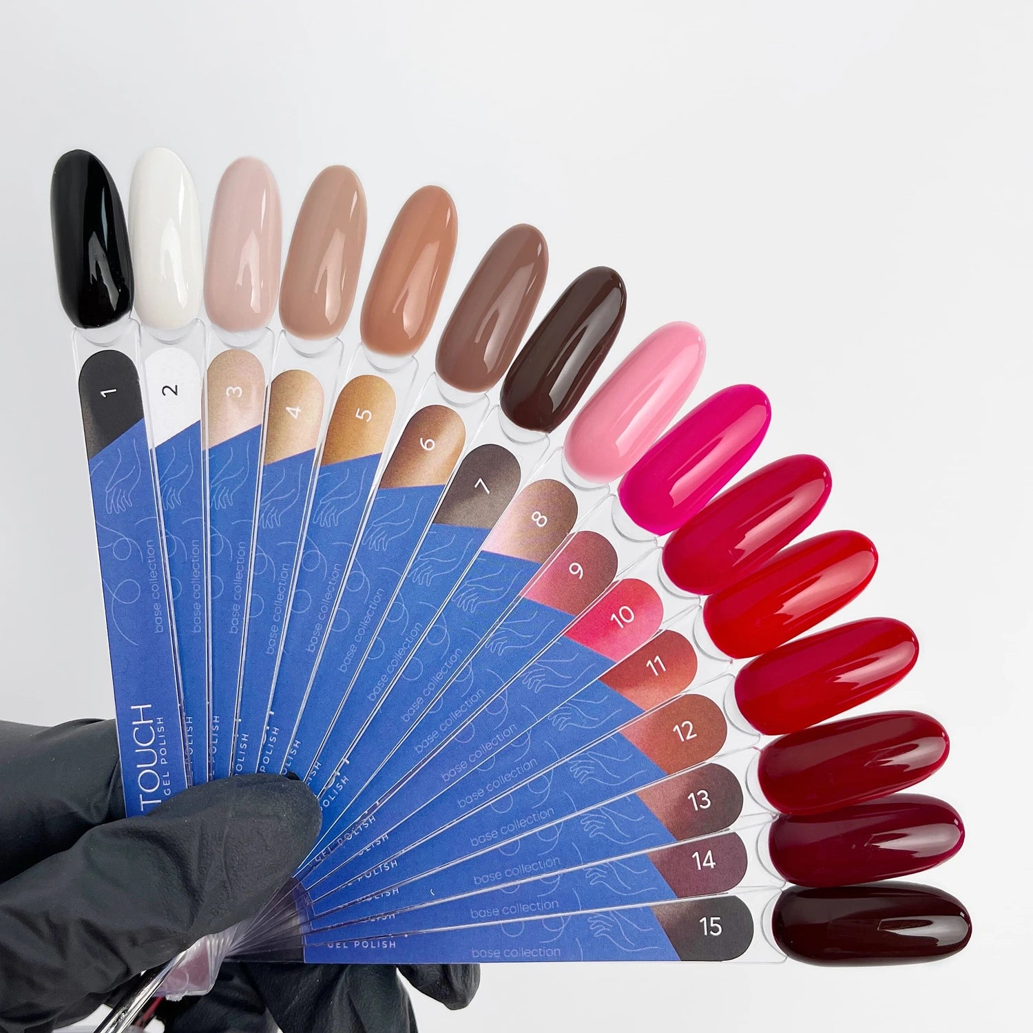 Hand holding nail polish color swatch palette with 15 gel polish shades for manicure