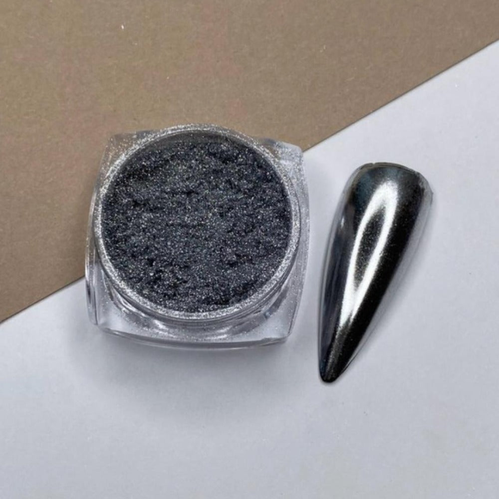 Black chrome nail powder in jar with swatch of mirror effect on artificial nail tip