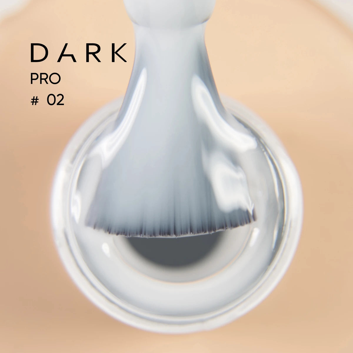 Close-up of nail polish brush dipped in nude UV gel polish, labeled DARK PRO #02