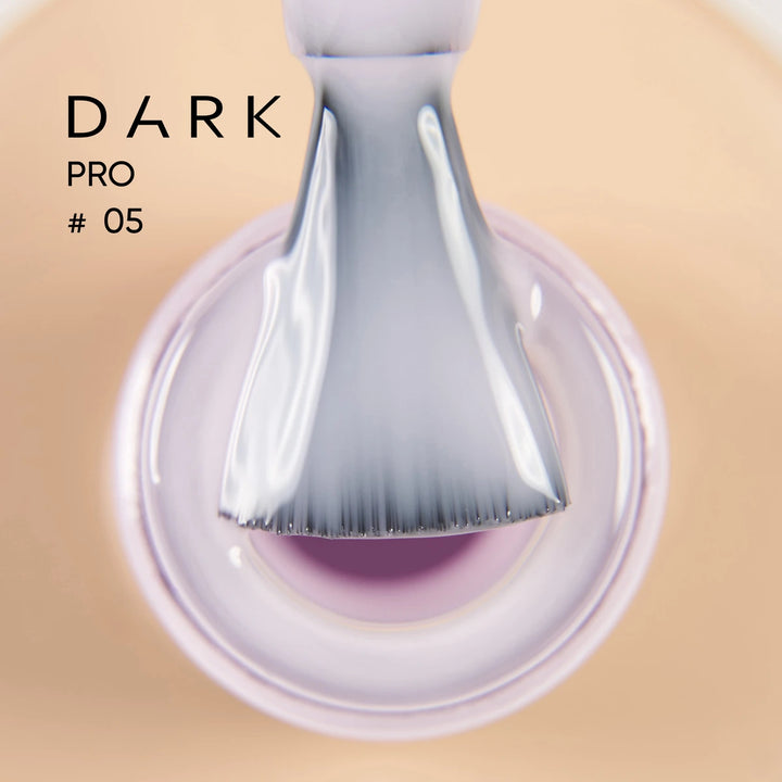 Close-up of a brush applying light purple nail gel polish, labeled Dark Pro 