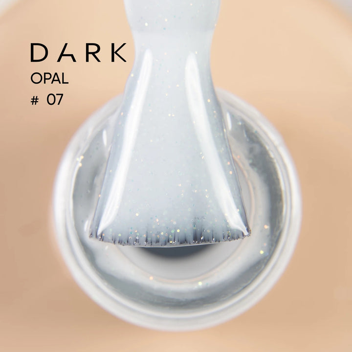 Close-up of brush with shimmery light opal gel polish, labeled Dark Opal 