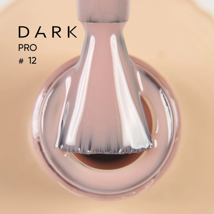 Close-up of nail polish brush with nude beige gel polish, labeled Dark Pro 