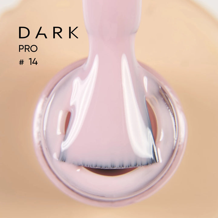 Close-up of a brush applying pale pink gel nail polish, labeled Dark Pro 
