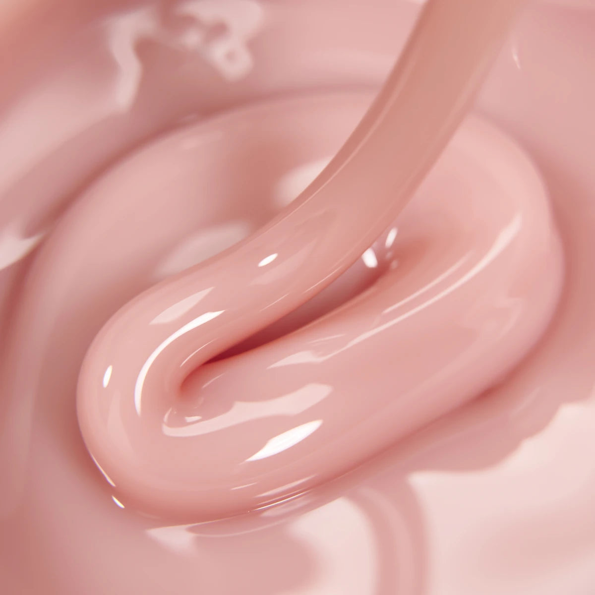 Close-up of thick, glossy light pink UV nail gel for manicures and nail extensions.