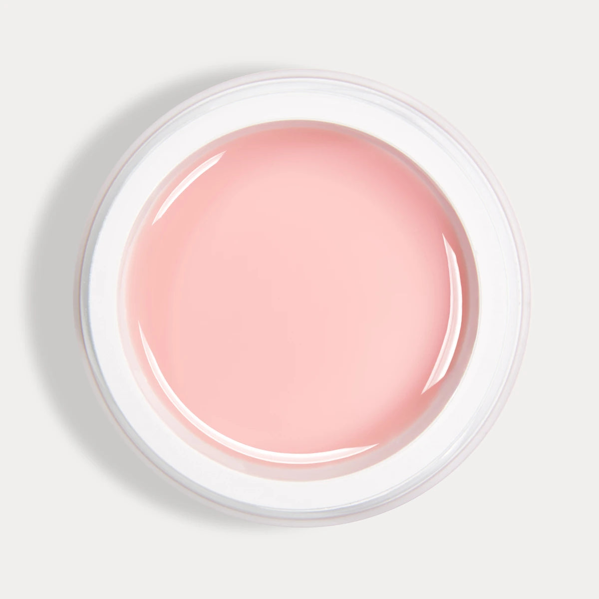 Open container of pink builder gel for nails on white background