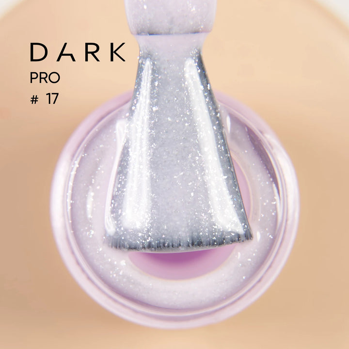 Close-up of a brush dipped in shimmery light purple gel nail polish, labeled Dark Pro 