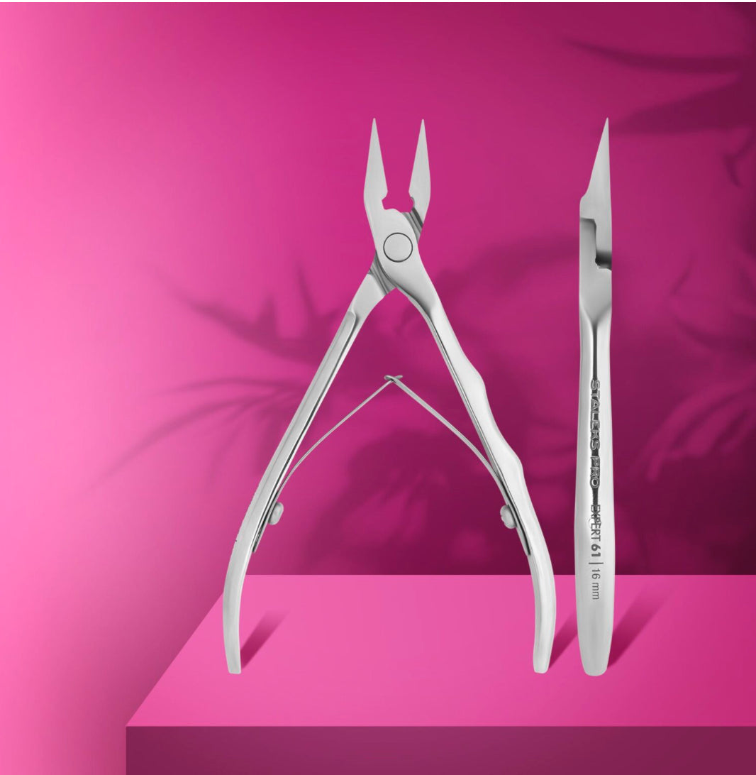 Stainless steel cuticle nipper and pusher for manicure on pink background