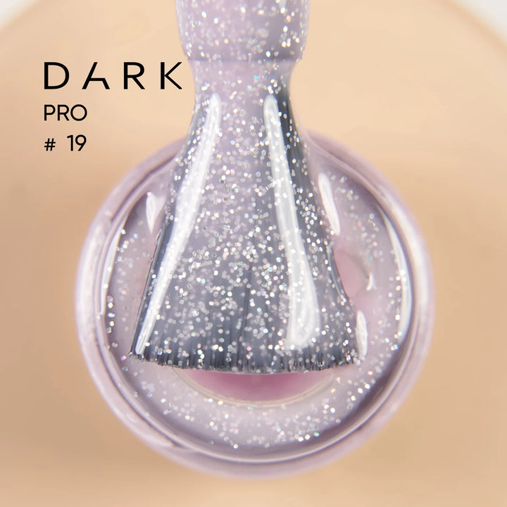 Close-up of nail polish brush with sparkly lilac glitter gel, manicure accessory