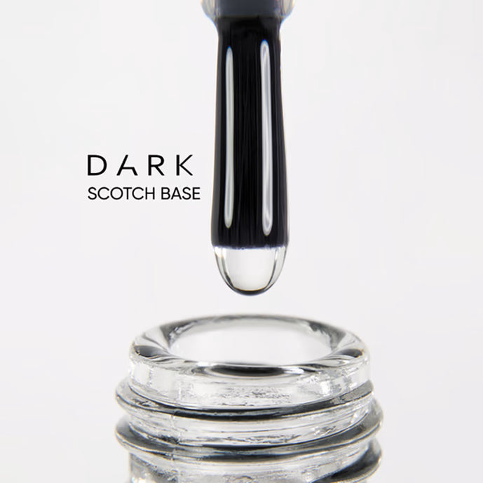Close-up of nail polish brush with dark scotch base gel above open bottle, manicure product