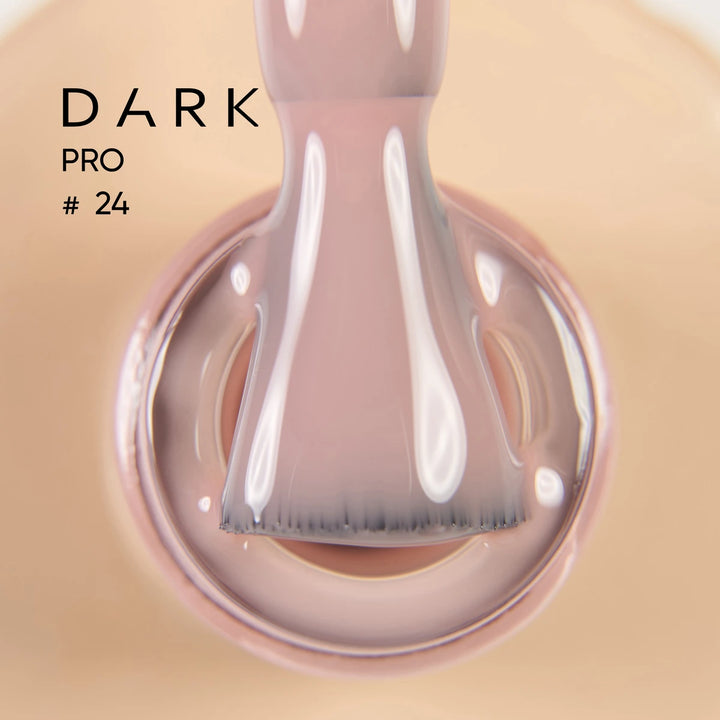 Nail polish brush dipped in nude pink gel polish, labeled Dark Pro 