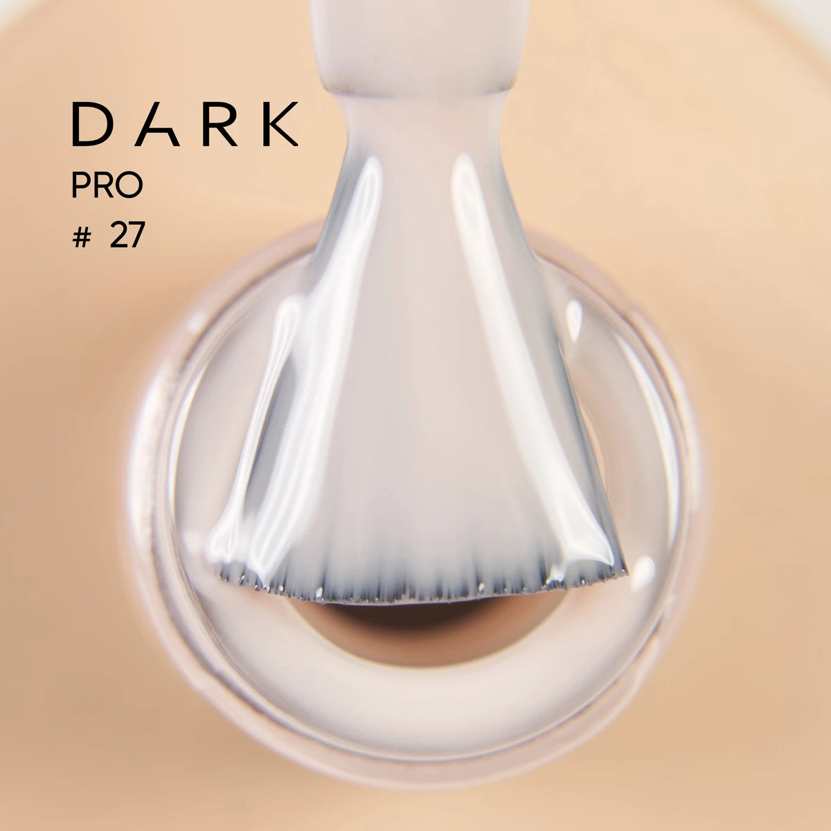 Close-up of brush applying nude gel polish, labeled Dark Pro #27, for manicure use