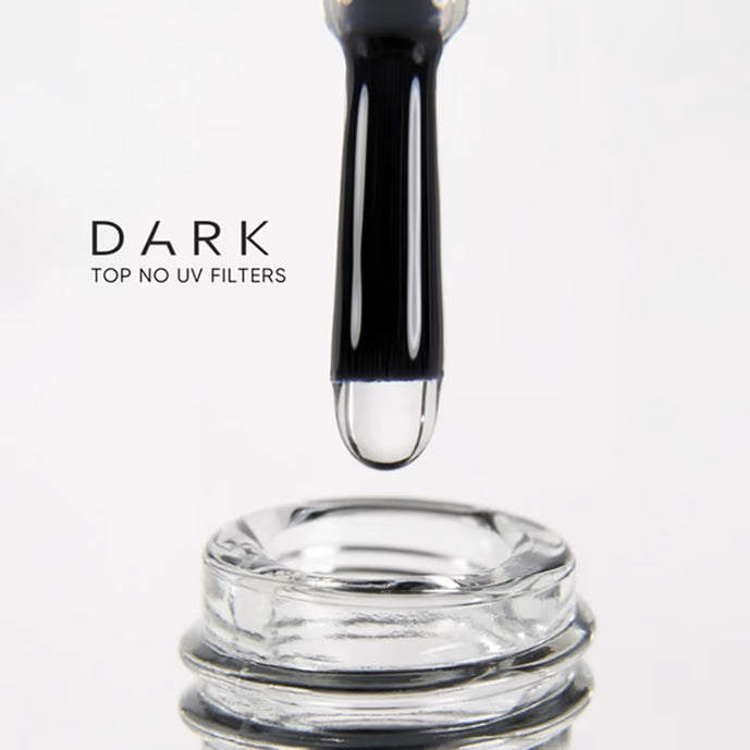Brush applying clear dark top coat for nails, no UV filters, manicure product close-up