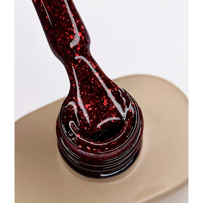 Red glitter gel nail polish on brush over open bottle, professional manicure product