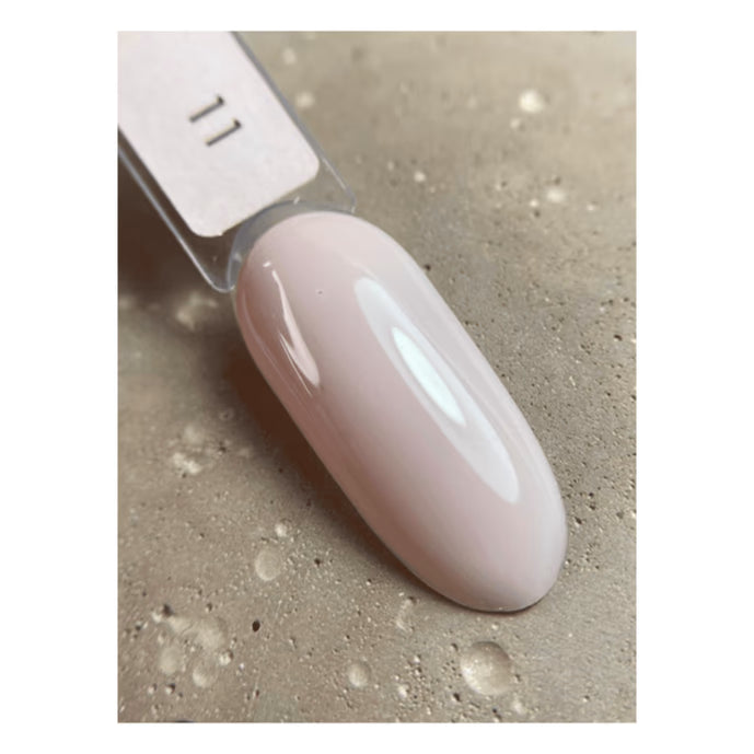 Swatch of light pink UV gel polish on nail tip, glossy finish, manicure nail sample