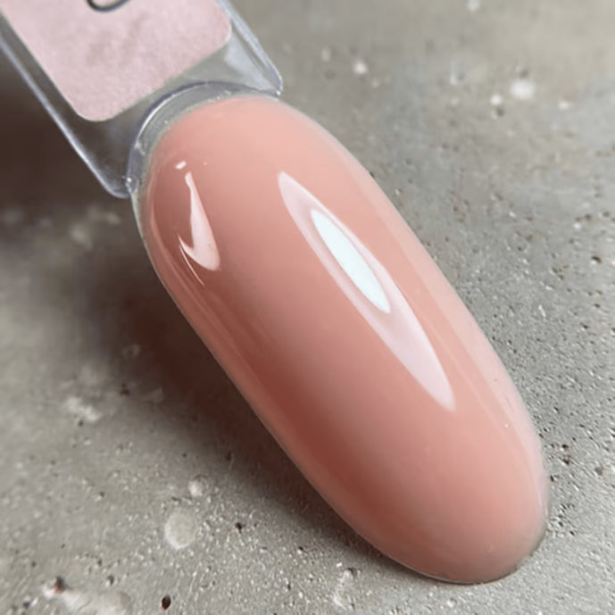 Glossy nude pink UV gel nail polish swatch on a sample nail tip
