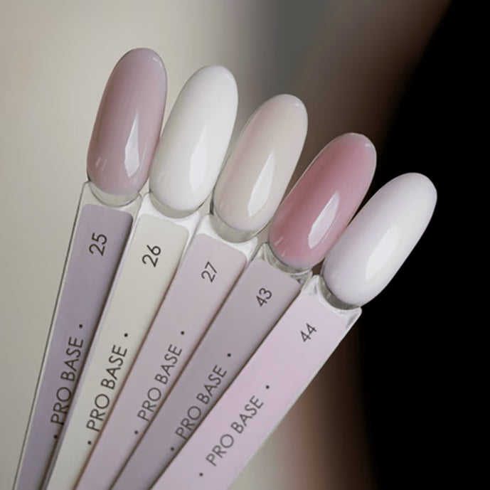 Swatches of nude and pastel gel nail polish shades on sample sticks, labeled Pro Base.