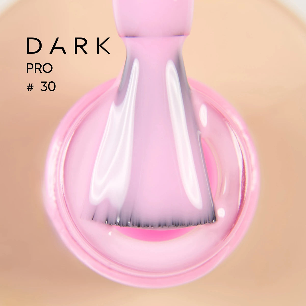 Close-up of a nail polish brush with glossy light pink UV gel for manicures.