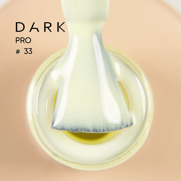 Close-up of nail polish brush with milky gel, labeled Dark Pro 