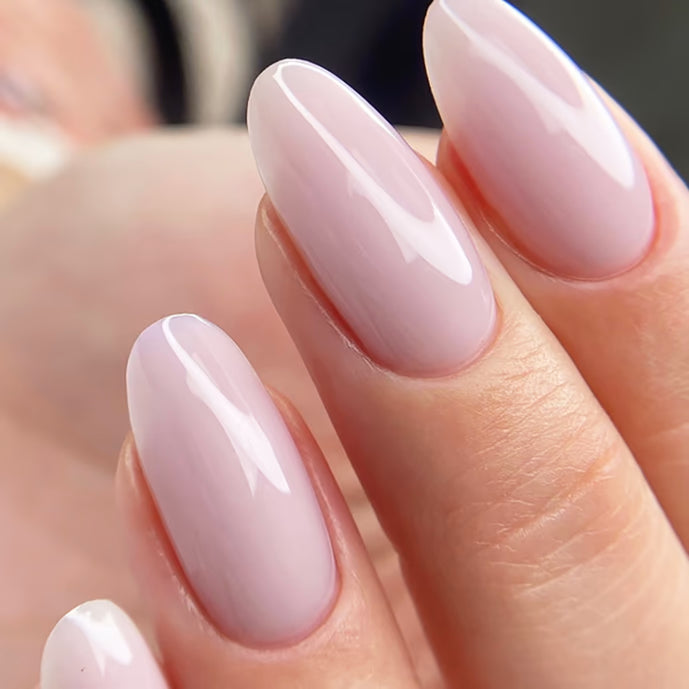 Close-up of almond-shaped nails with glossy pale pink gel polish manicure
