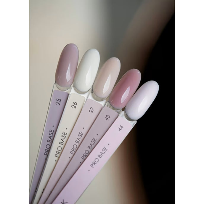 Assorted nude and pastel gel nail polish swatches labeled Pro Base on display sticks