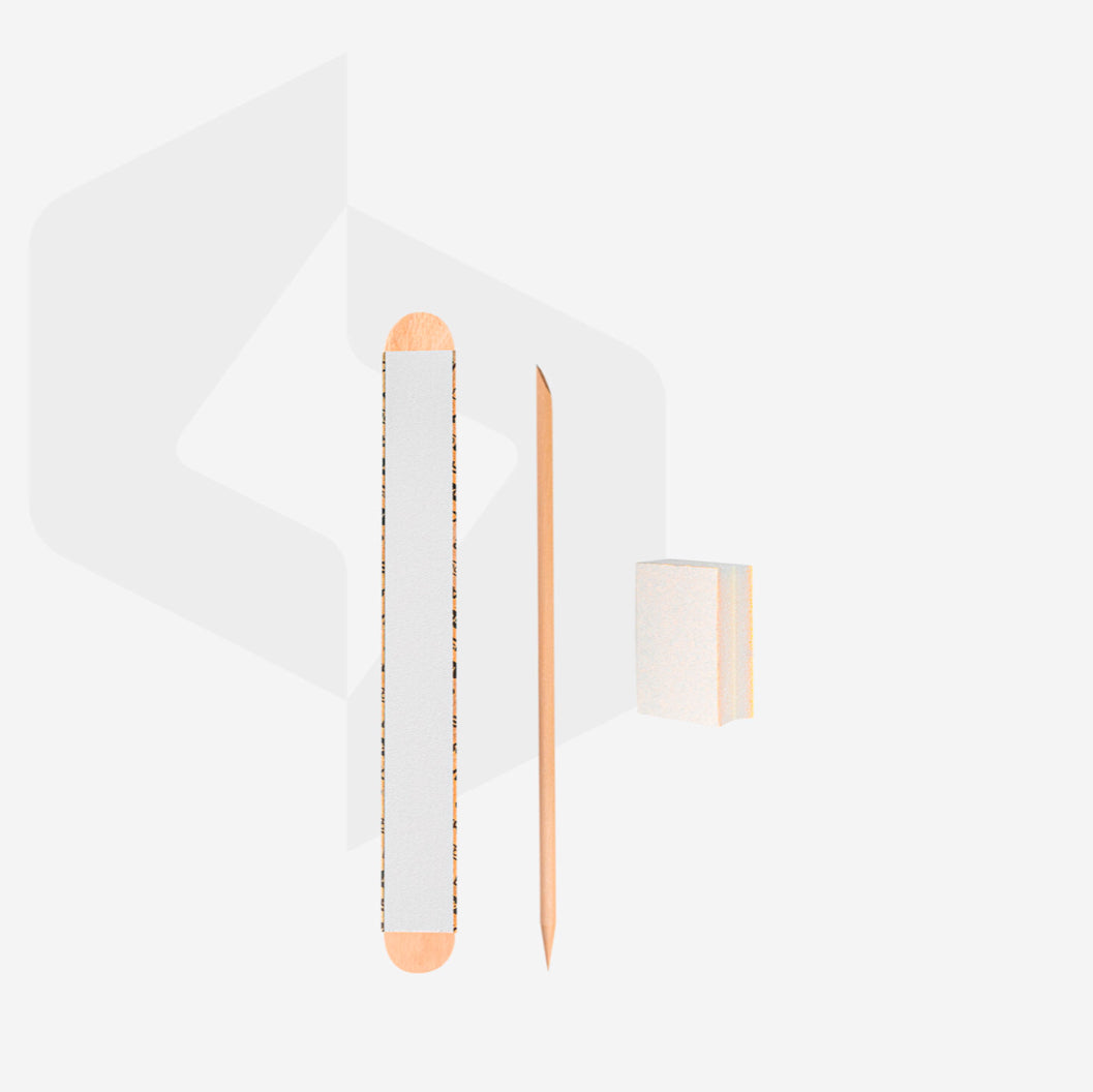 Nail care set with nail file, wooden cuticle stick, and mini buffer block on white background
