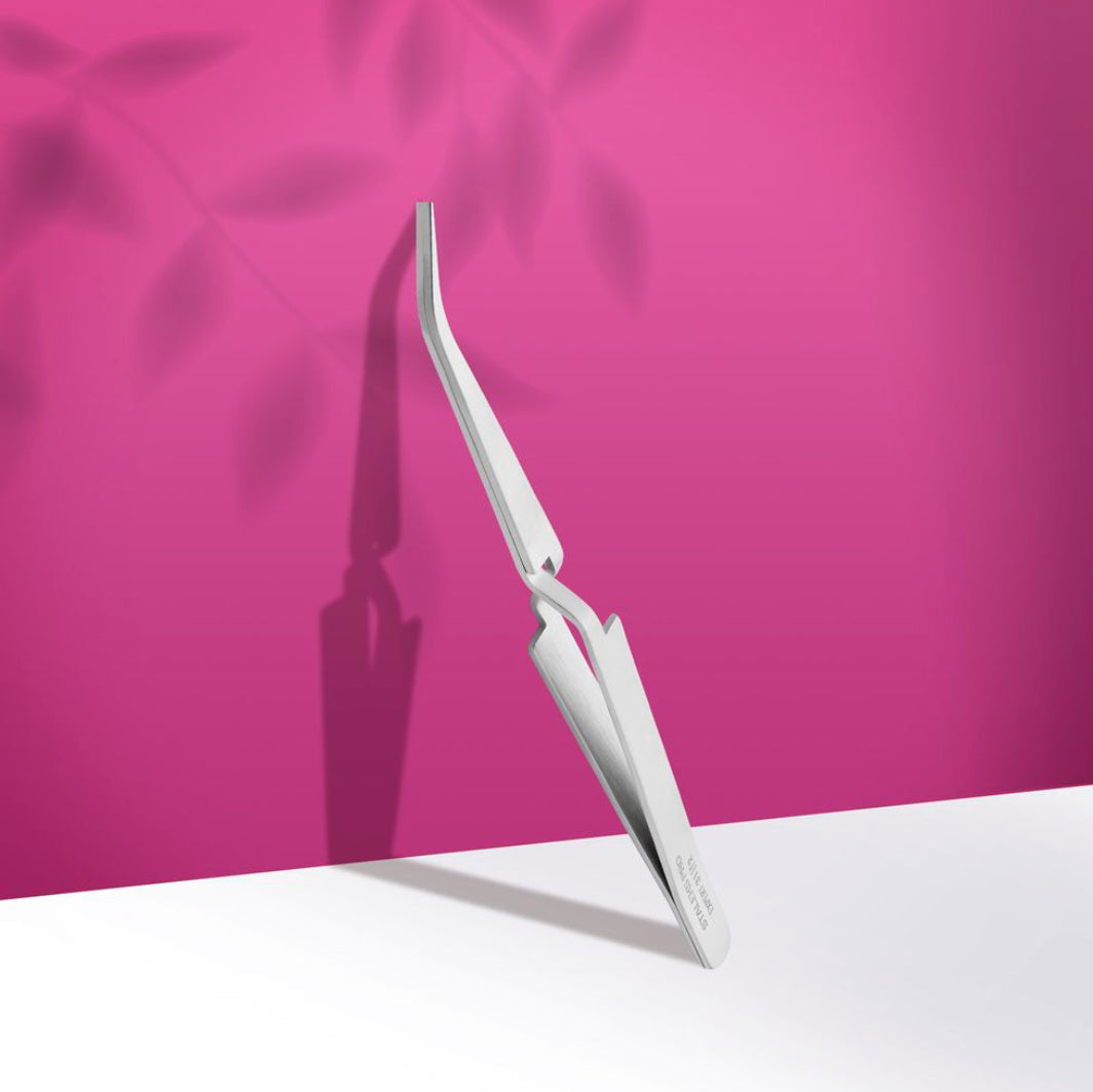 Stainless steel nail art tweezer on pink background for professional manicure