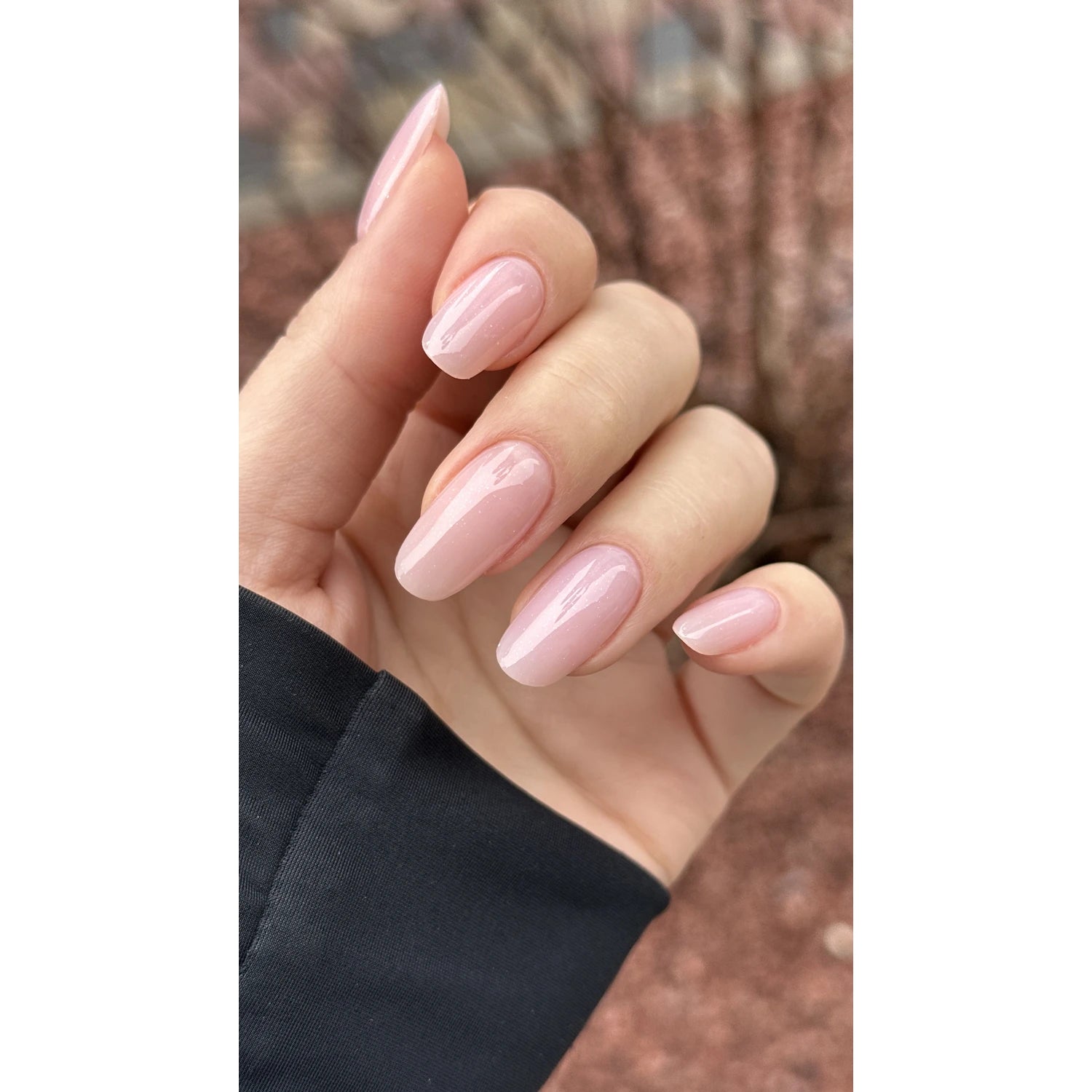 Hand with glossy light pink manicure, oval-shaped nails, professional nail polish