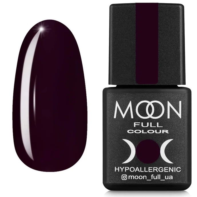 Dark red nail polish bottle with a dark purple nail next to it on a white background