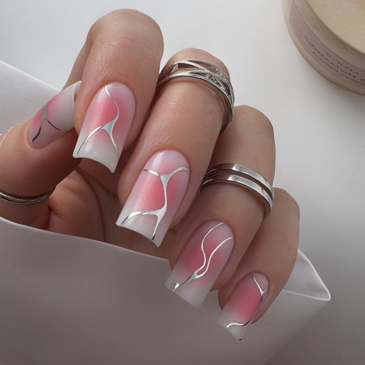 Square nails with pink and white ombre gel polish, silver abstract nail art, manicure accessories