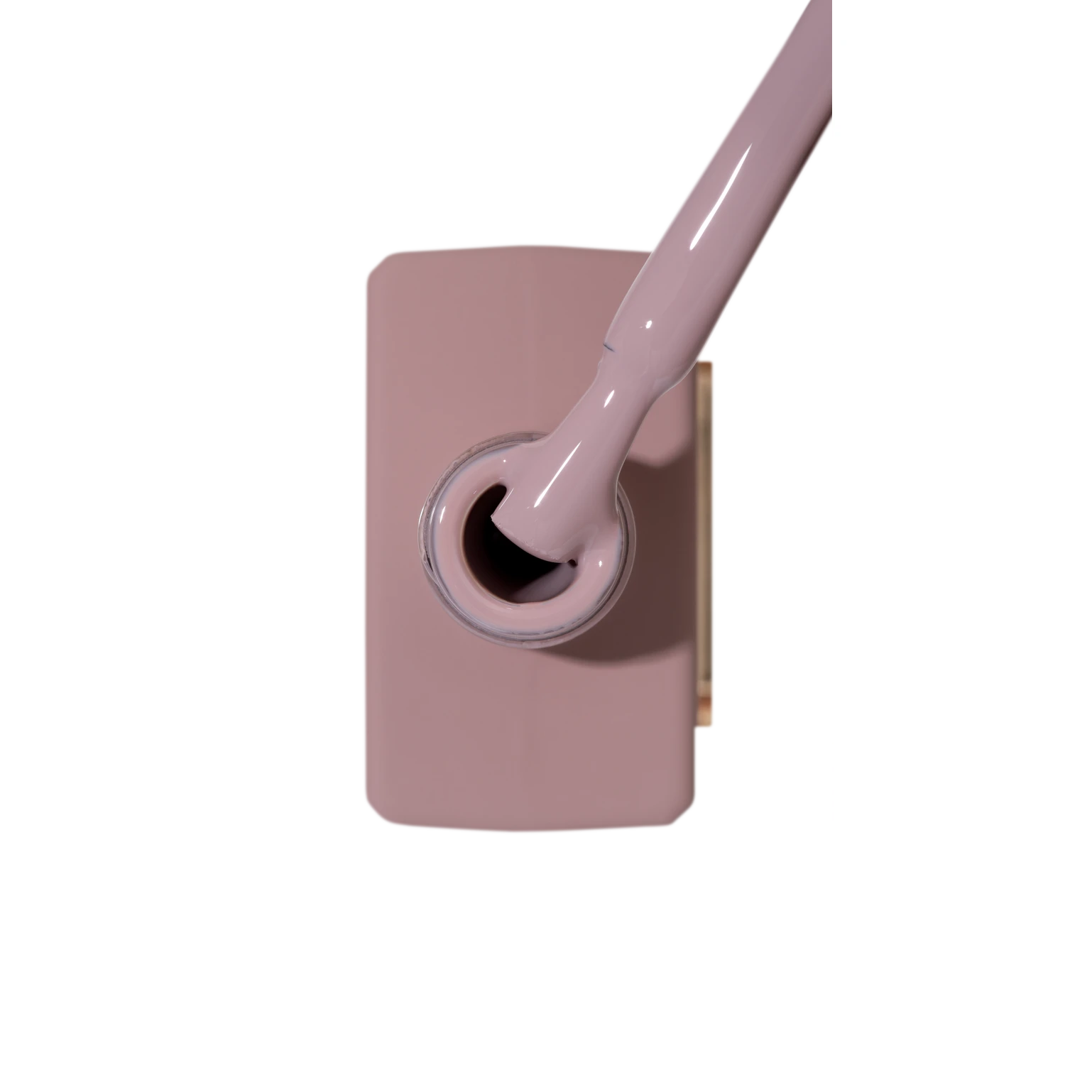 Open bottle of mauve nail gel polish with brush applicator