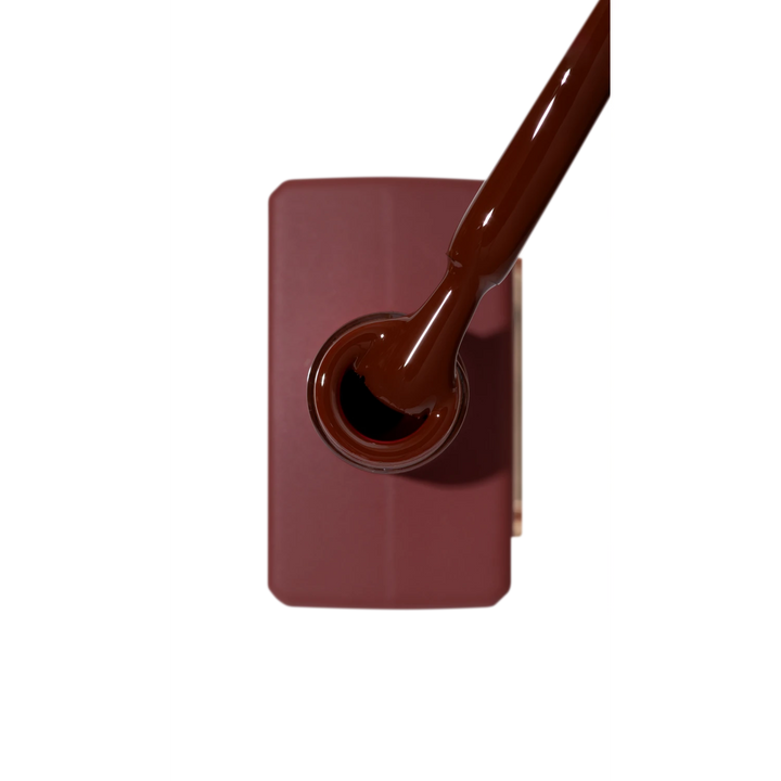 Brown gel nail polish bottle with applicator brush, top view, professional manicure supply
