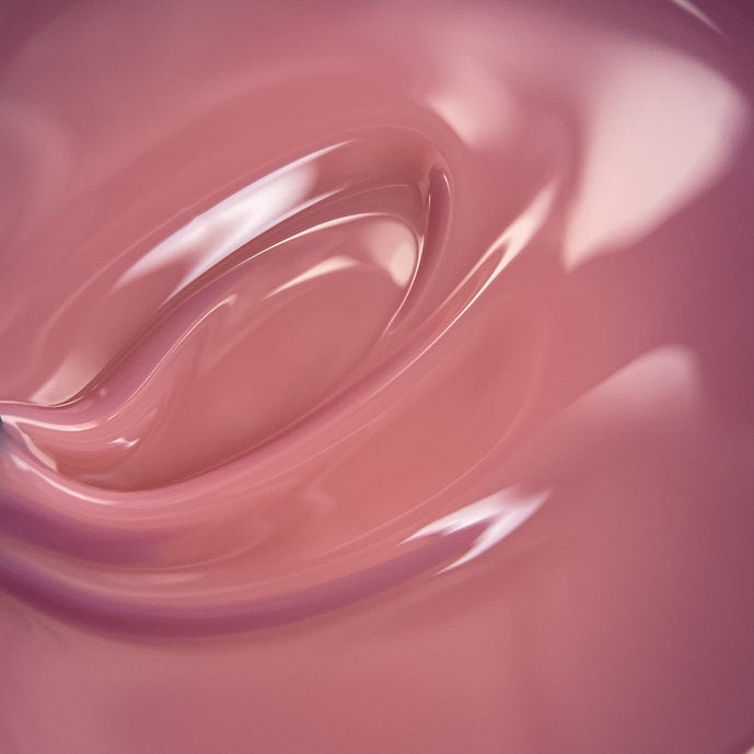 Close-up of glossy pink builder gel texture for nails, manicure product