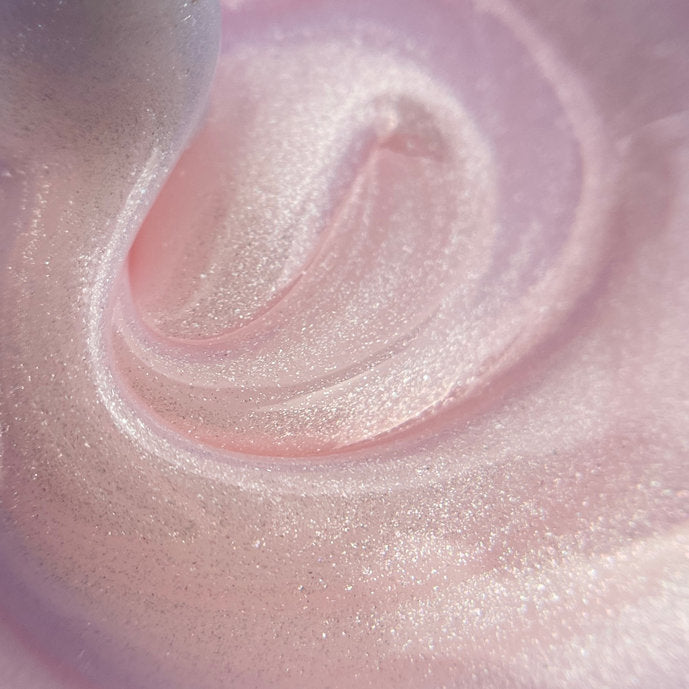 Close-up of shimmering pink builder gel for nails, smooth creamy texture.