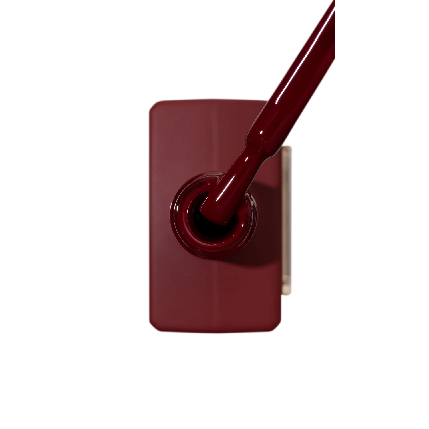 Burgundy gel nail polish bottle with applicator brush, professional manicure supplies