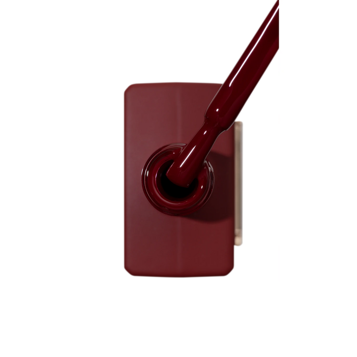 Burgundy gel nail polish bottle with applicator brush, professional manicure supplies