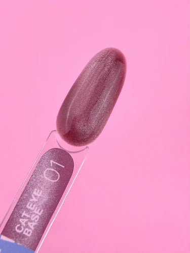 Cat eye gel nail polish swatch in shimmery mauve pink on sample stick against pink background