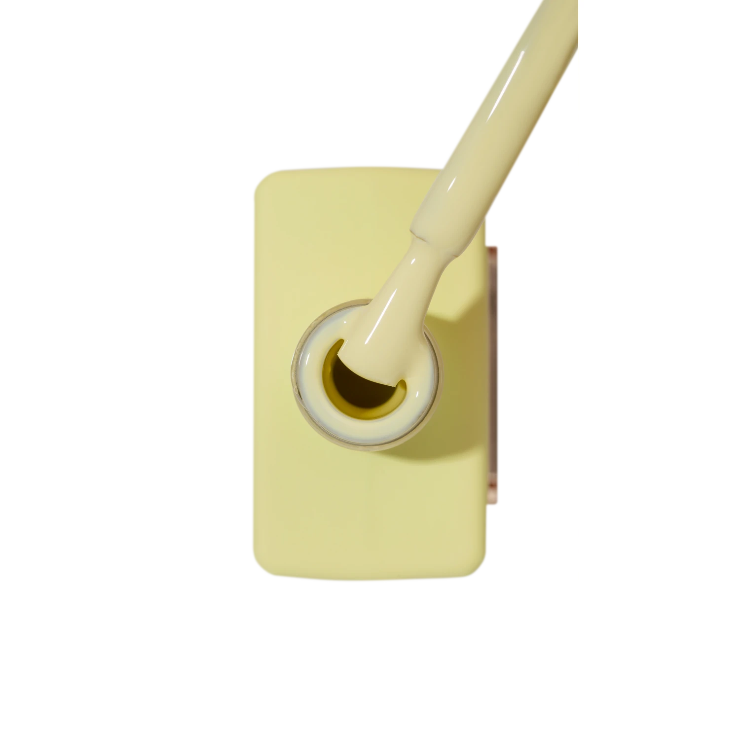 Pale yellow gel nail polish bottle with applicator brush, manicure supplies