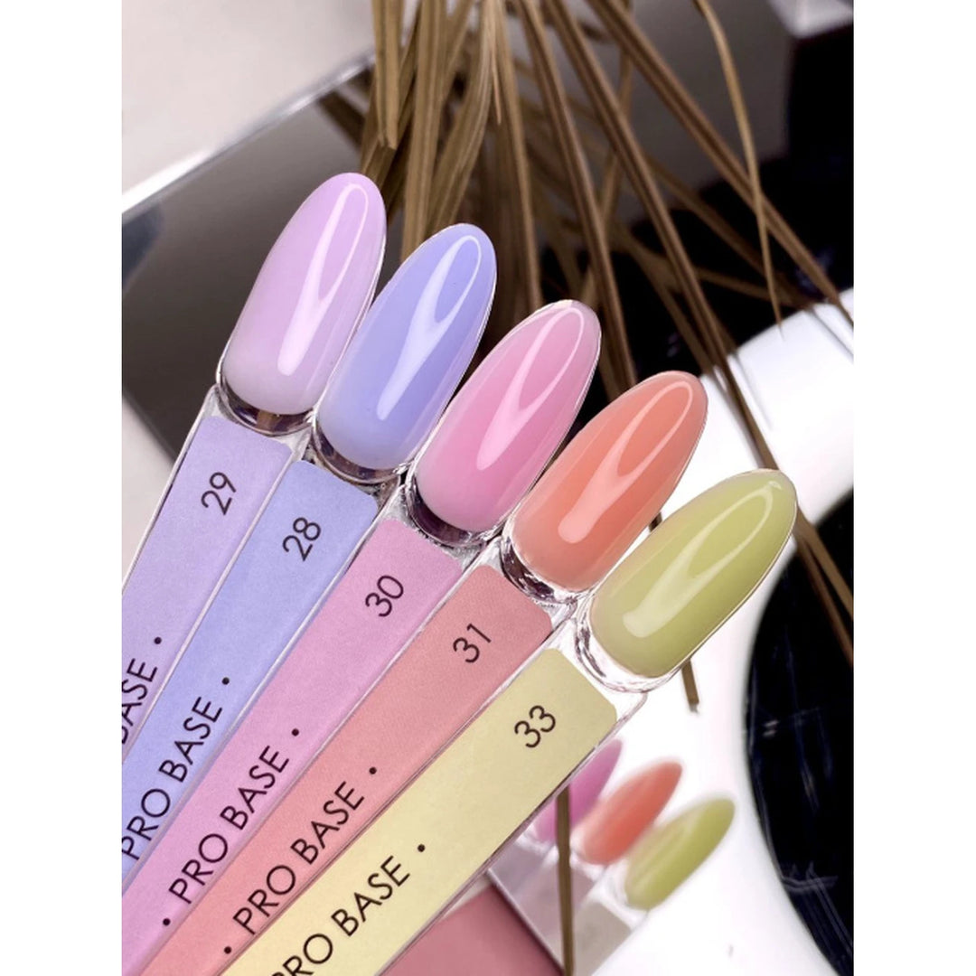 Five nail tip samples in pastel UV gel colors, labeled 28-33, for manicure display.