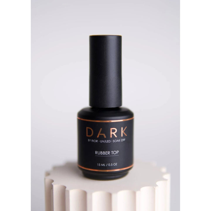 Black bottle of DARK Rubber Top UV/LED soak off nail gel, 15ml, on neutral pedestal