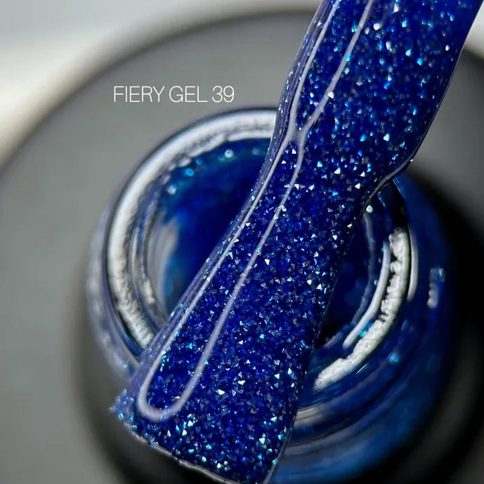 Close-up of blue glitter gel nail polish brush and open jar labeled FIERY GEL 39
