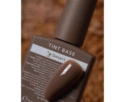 Brown gel nail polish bottle labeled Tint Base Desert with matching nail tip