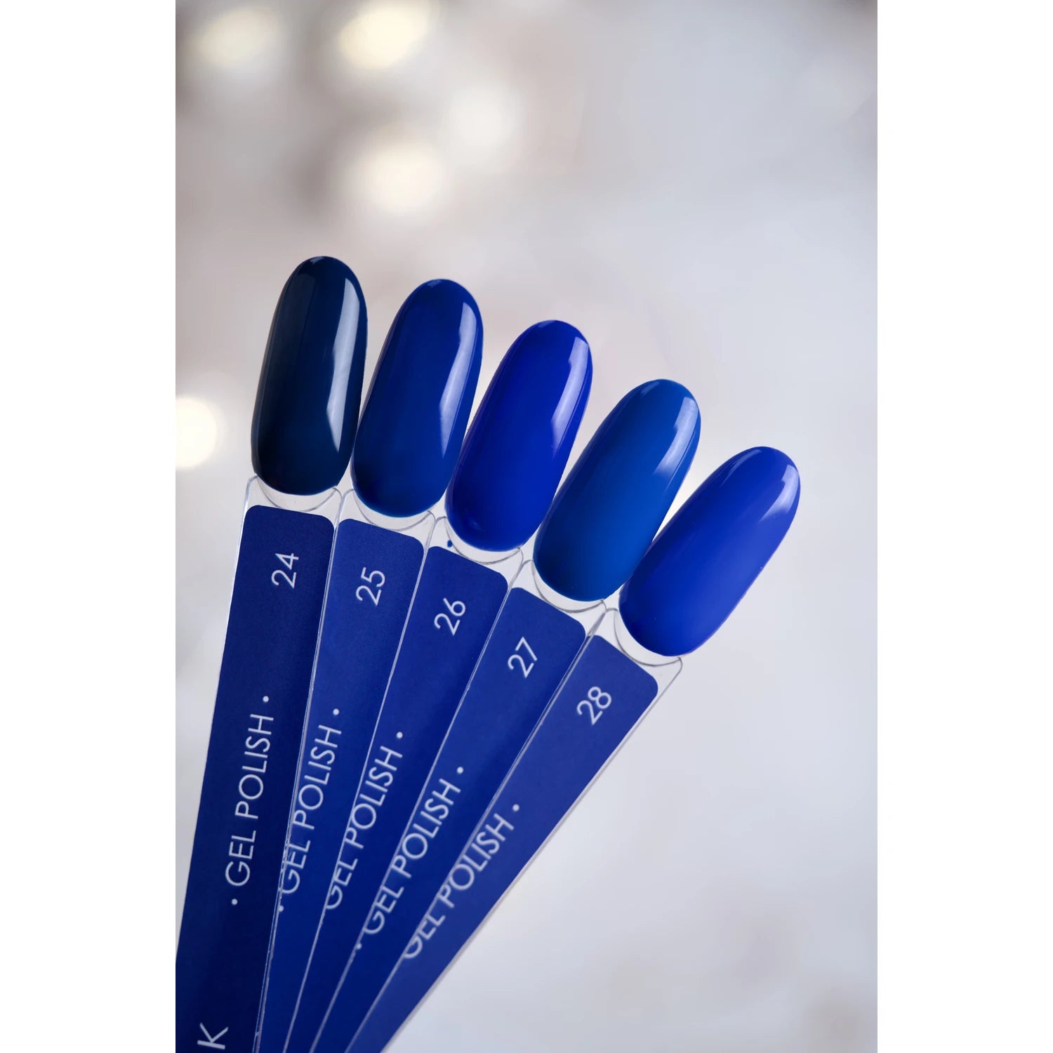 Blue gel polish nail color swatches arranged in a fan on a light background