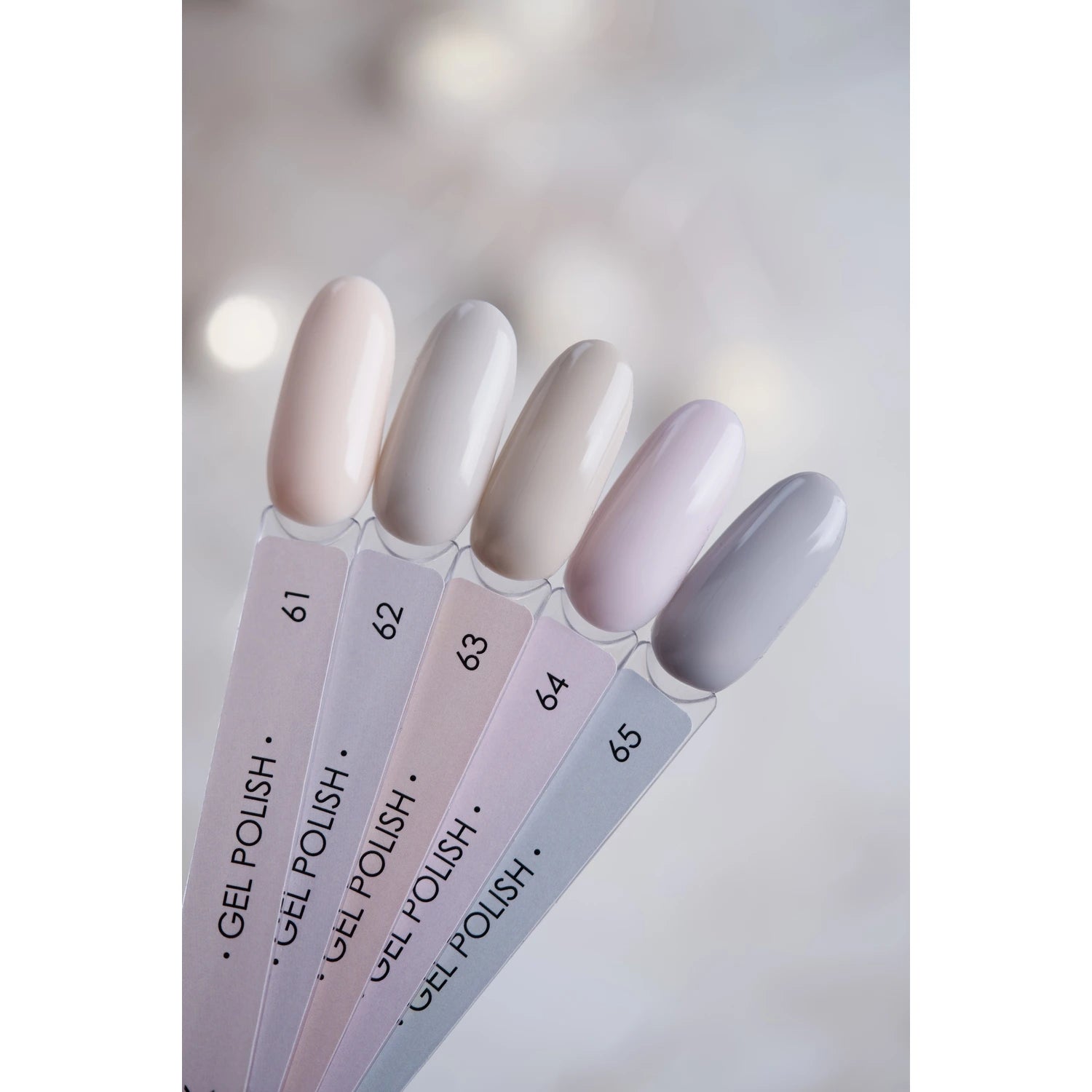 Neutral nude and grey gel polish color swatches for manicure on clear sample sticks