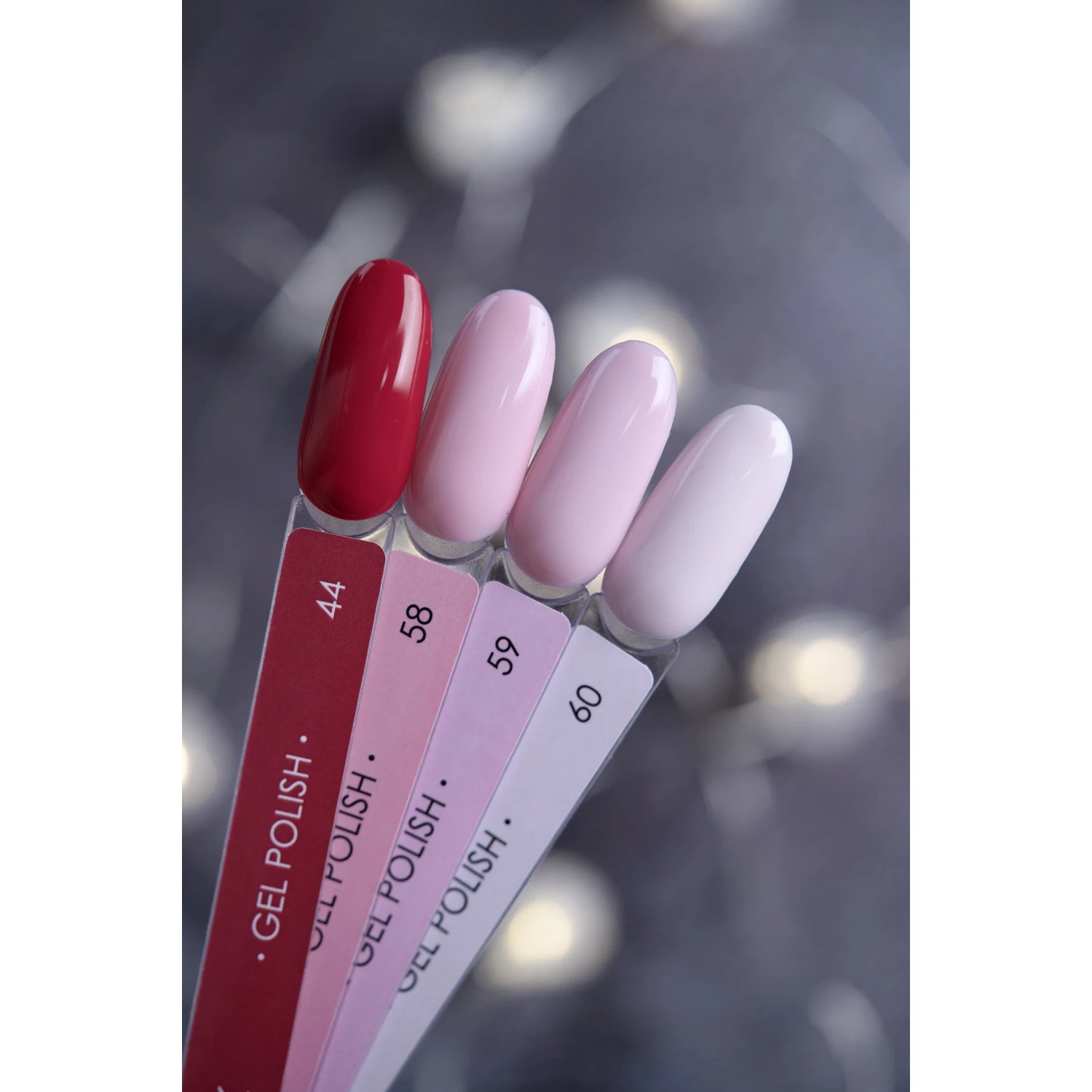 Gel nail polish color swatches in red and pink shades on display sticks
