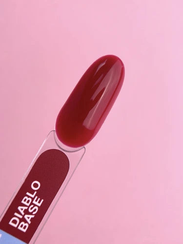 Deep red gel nail polish swatch labeled Diablo Base on a pink background