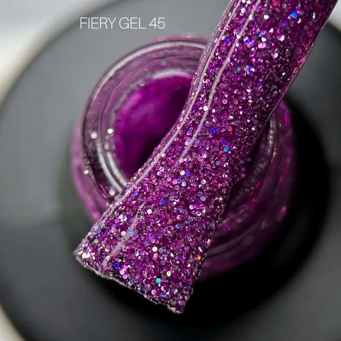 Purple glitter UV gel polish for nails in open jar with brush applicator