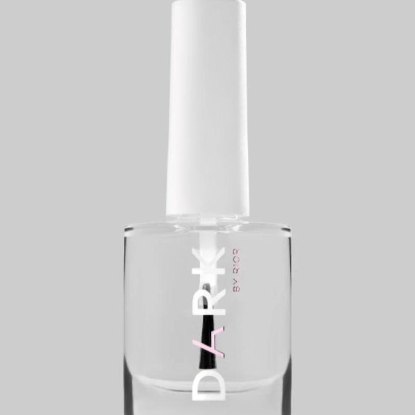 Clear nail polish bottle with white cap for manicure and pedicure, grey background
