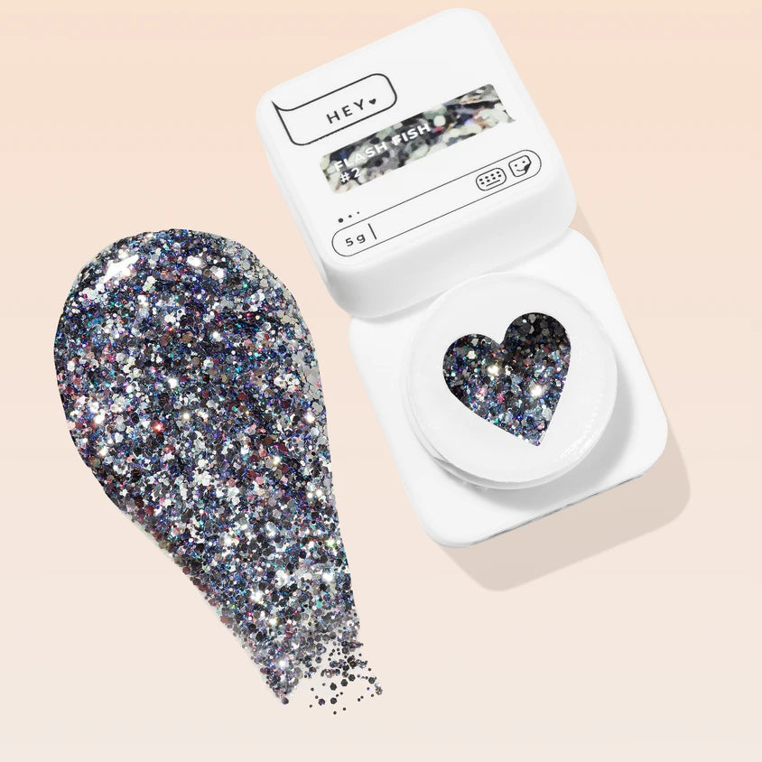 Glittery silver and multicolor nail gel in a white container with a heart-shaped window